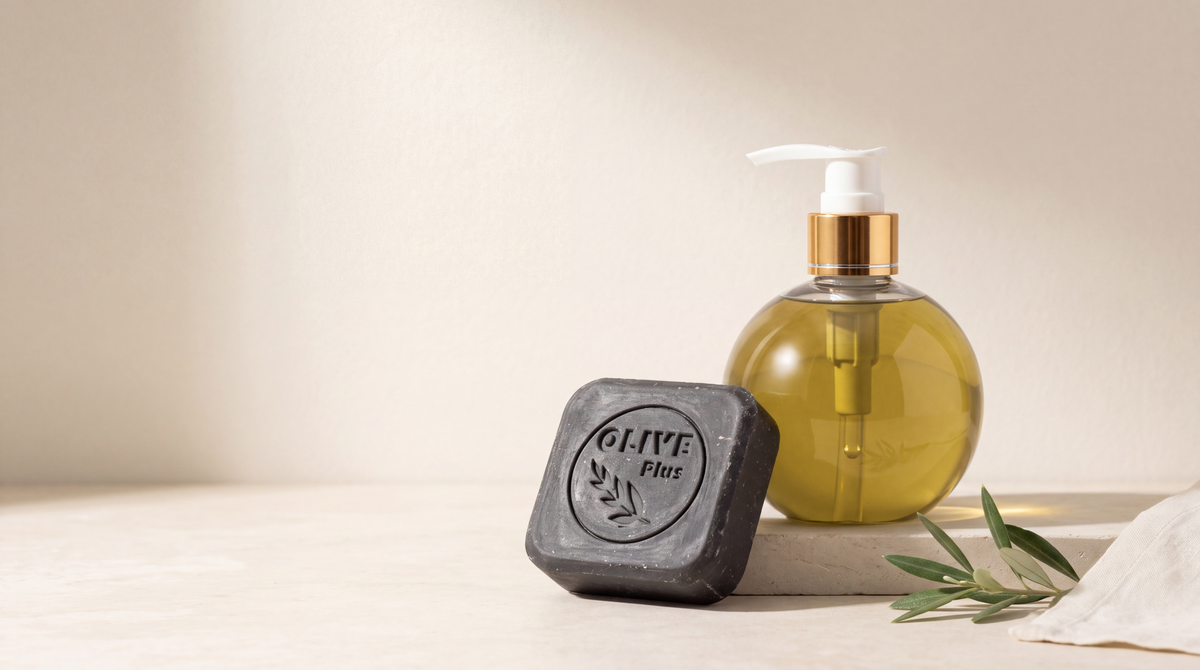Olive Plus soap bar and olive-oil liquid soap on pale limestone with olive leaves